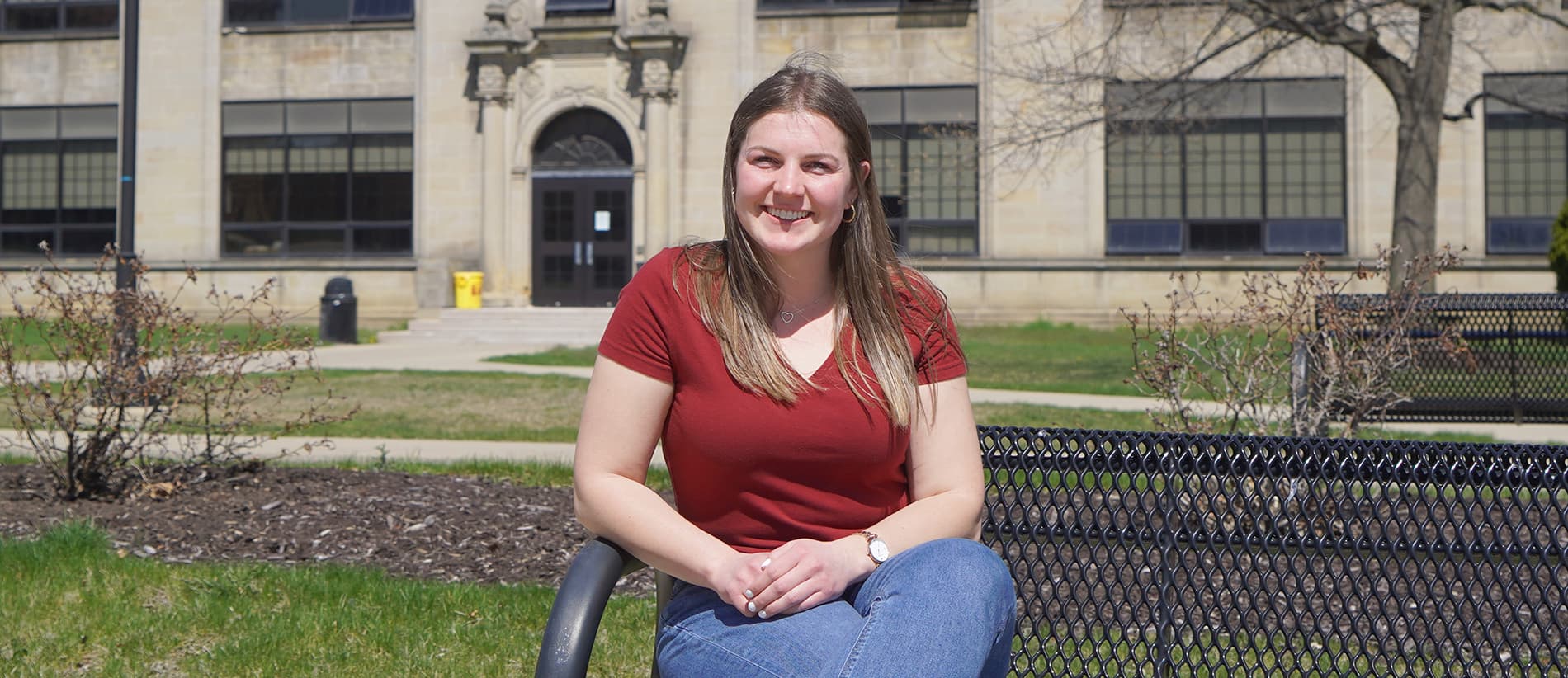 Kirstin Finnila sits on a bench outside of the Engineering Building on UDM’s McNichols Campus.