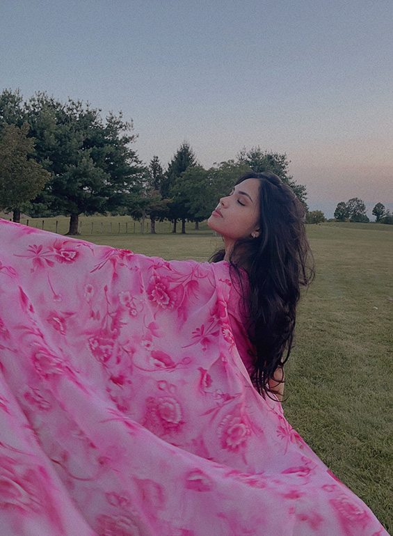 Nisha Miah poses for a photo while wearing a pink shawl.